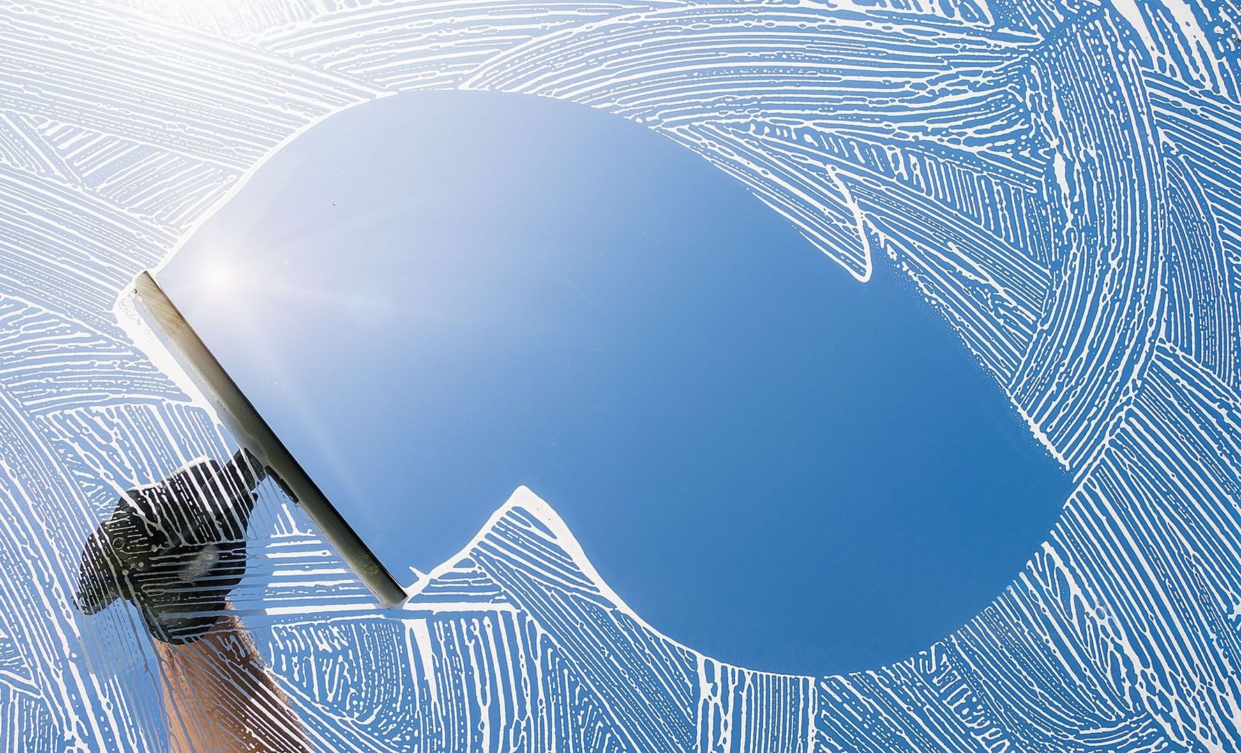 Fenster wird mit einen Hand-Scheibenwischer gereinigt
